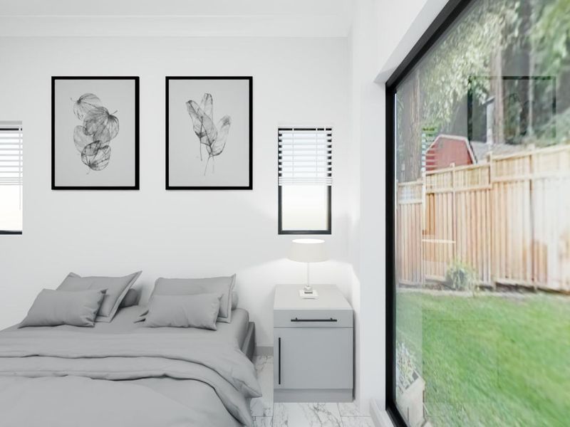 Modern bedroom featuring large sliding glass doors with garden views, marble-look flooring, built-in wardrobe, and dual casement windows with venetian blinds.