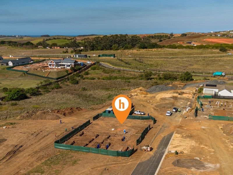 Aerial view of a residential construction site showing foundation trenches and site preparation within a developing estate.