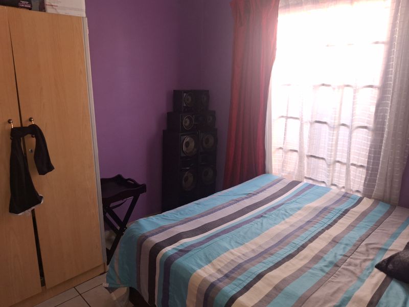 A bedroom featuring tiled flooring and a window with natural light.