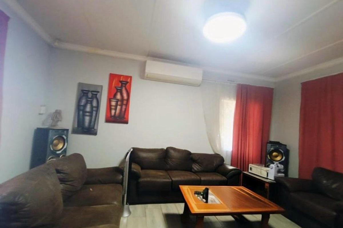 A living room featuring tiled flooring and a wall-mounted split-system air conditioner.