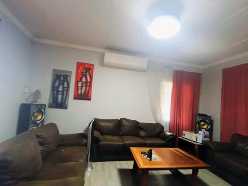 A living room featuring tiled flooring and a wall-mounted split-system air conditioner.