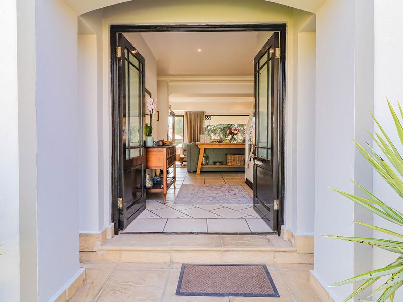 Inviting entrance featuring double doors opening into a bright, tiled living space with a clear view through to the interior.