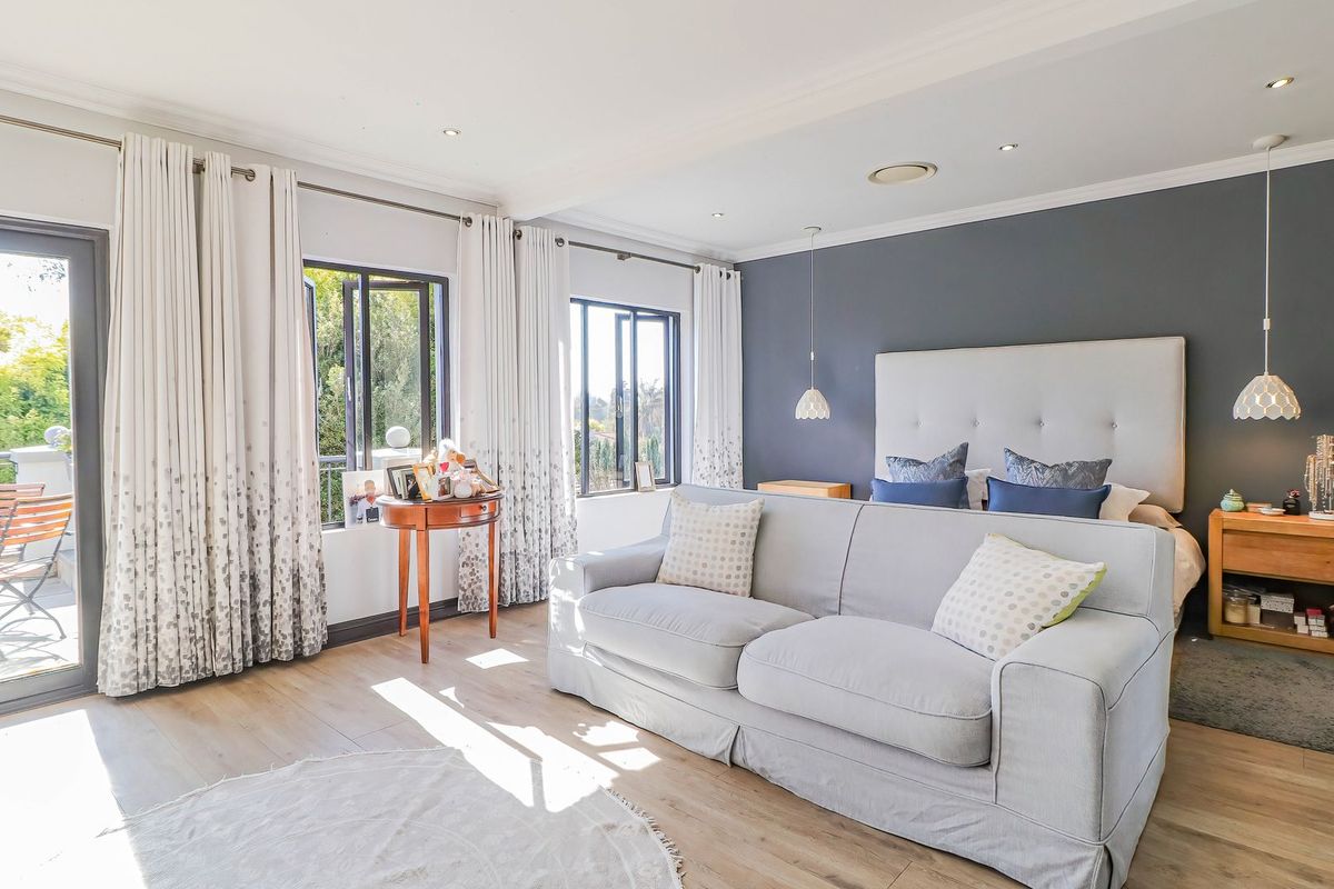 Spacious bedroom featuring laminate flooring, recessed lighting, and direct access to a private balcony through sliding glass doors.