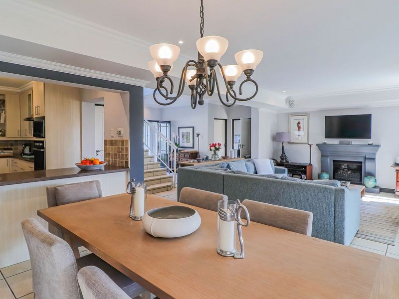 Spacious open-plan living area featuring a dining space, a well-appointed kitchen with built-in cabinetry, and a cozy lounge with a fireplace.