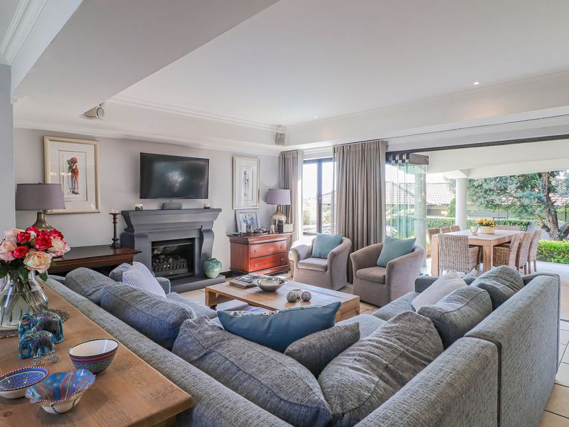 Spacious open-plan living area featuring a fireplace, recessed lighting, and seamless flow to an outdoor patio through large sliding glass doors.