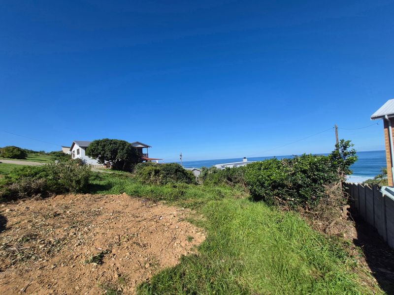 A scenic view overlooking the coastline and ocean from the residential land plot, showcasing the natural landscape and surrounding neighborhood.