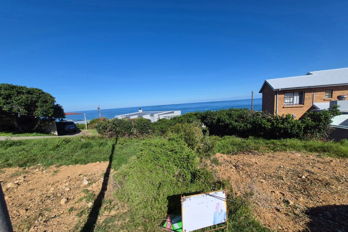 A vacant residential plot offering expansive ocean views, situated in a coastal neighborhood with established surrounding properties.