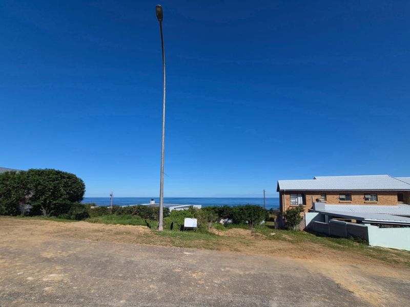 A clear view of the ocean from the vacant residential land, featuring a street light and surrounding neighborhood context.