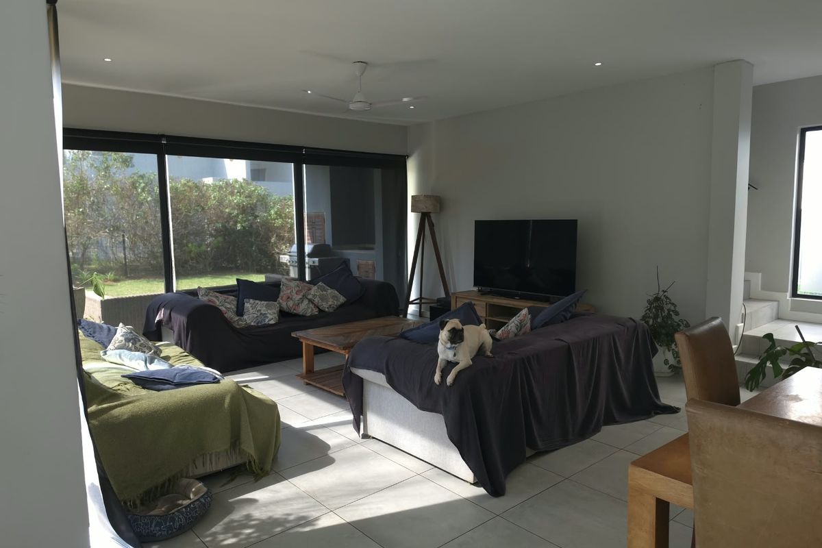 Spacious living area featuring large sliding glass doors that provide natural light and direct access to the outdoor garden space.