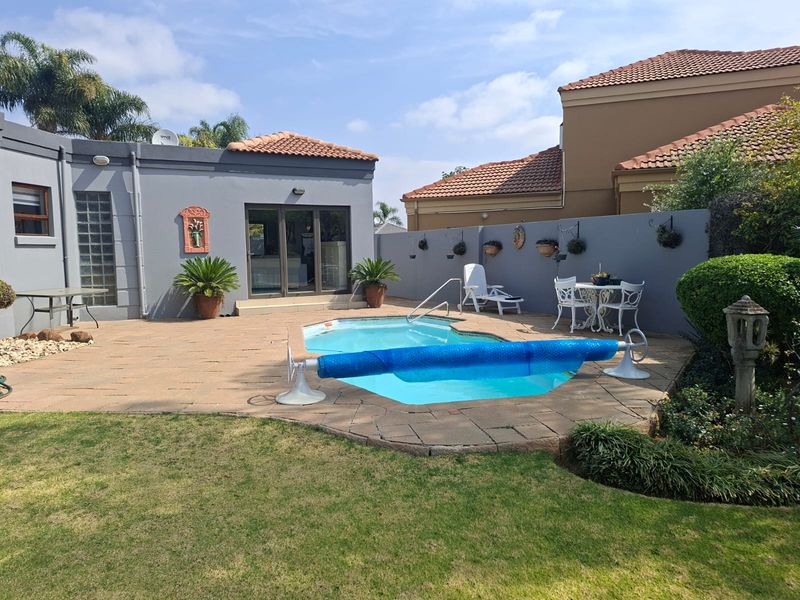 A private outdoor pool area featuring a paved patio, swimming pool with cover, and direct access to the home via glass sliding doors.