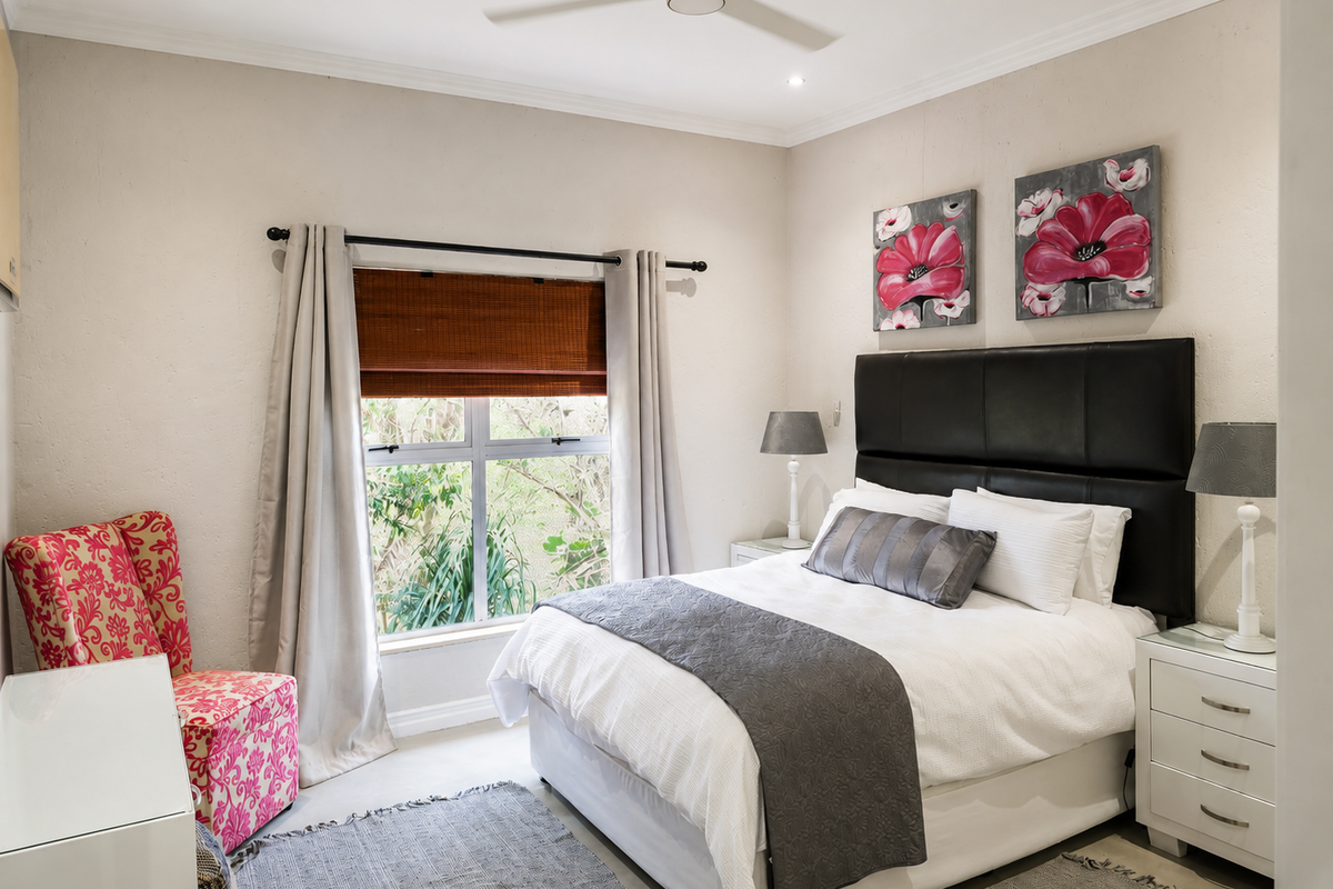 A well-maintained bedroom featuring neutral walls, recessed downlighting, a ceiling fan, and large windows providing natural light and garden views.
