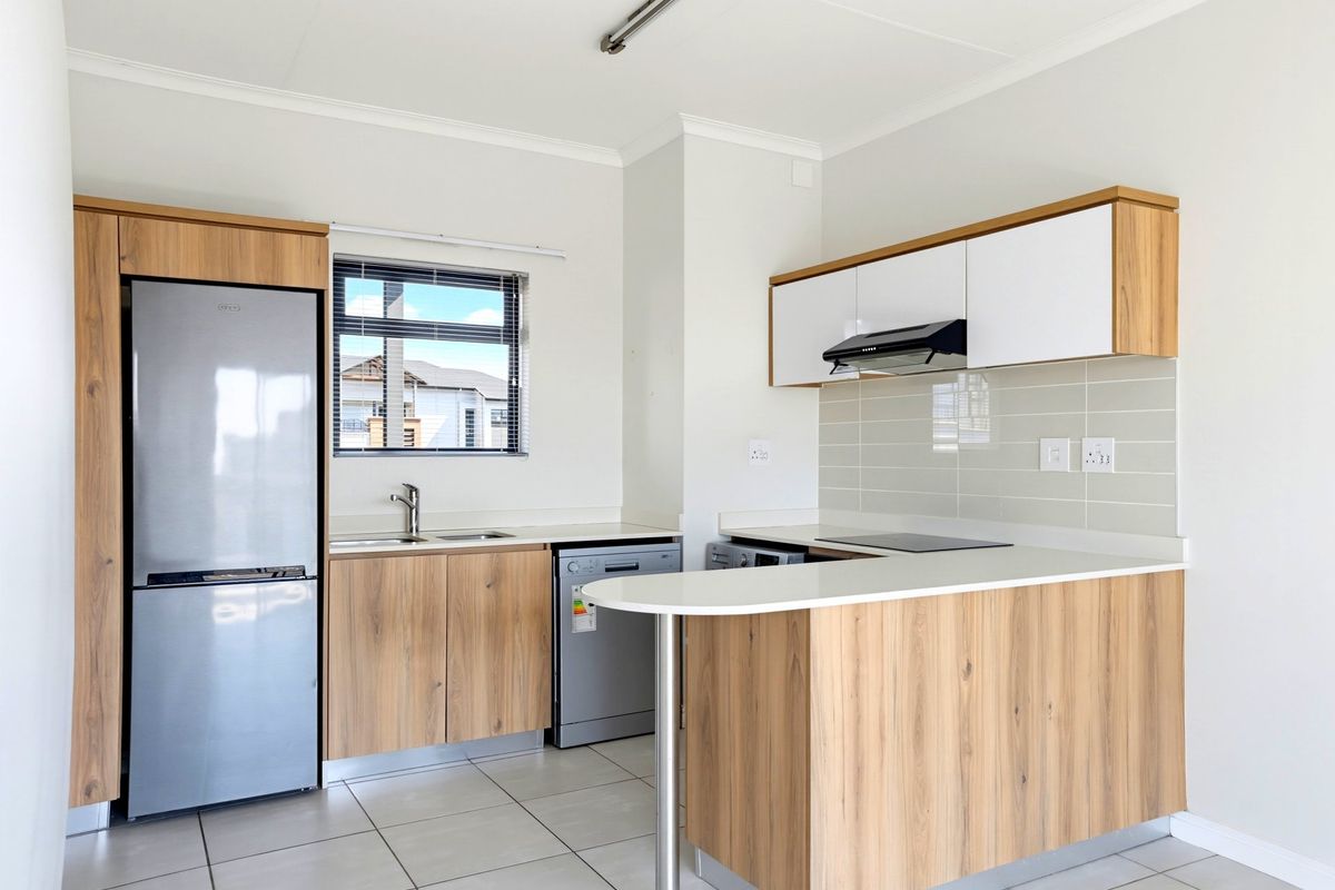 Modern kitchen featuring wood-finish cabinetry, stone countertops, integrated hob with extractor, and a functional breakfast bar layout.