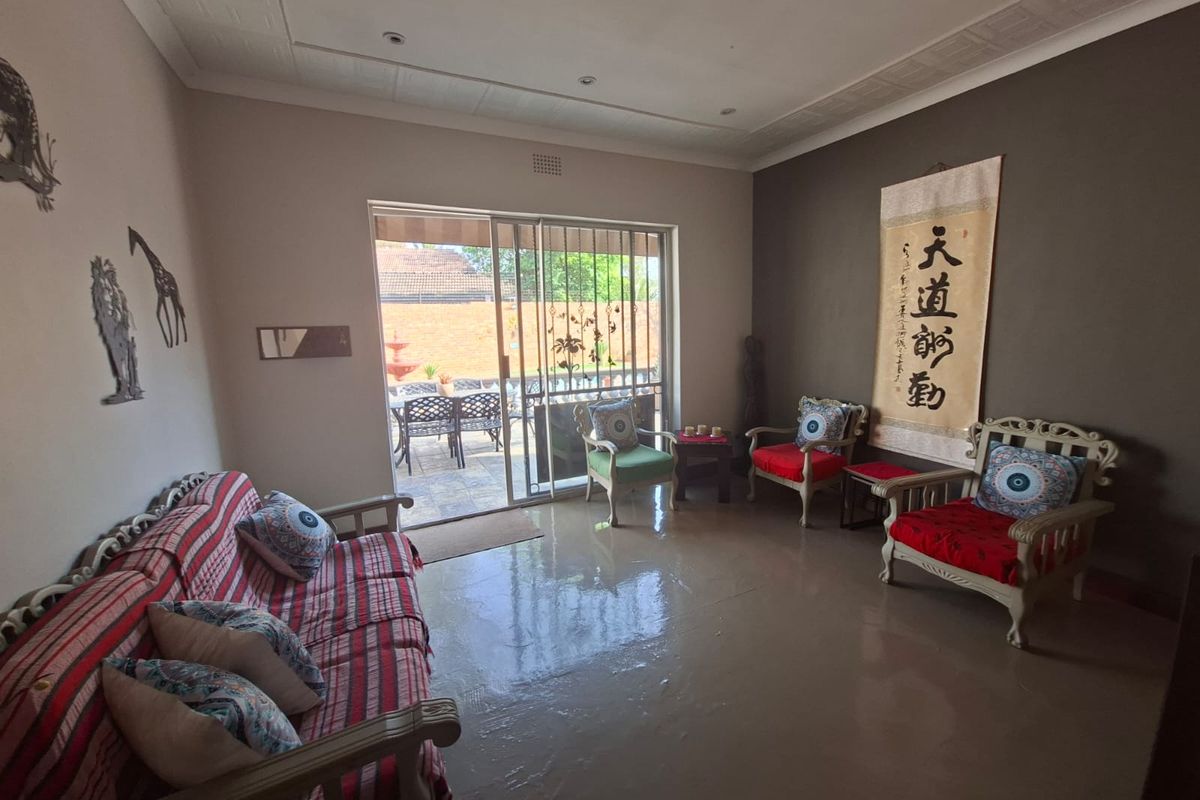 A living room featuring tiled flooring, recessed lighting, and a large sliding glass door providing access to an outdoor patio area.