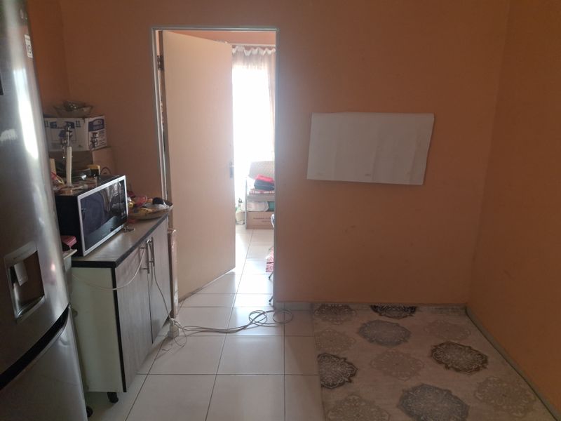 A small kitchen area featuring tiled flooring and basic cabinetry, requiring cosmetic updates to improve the overall aesthetic and finish.