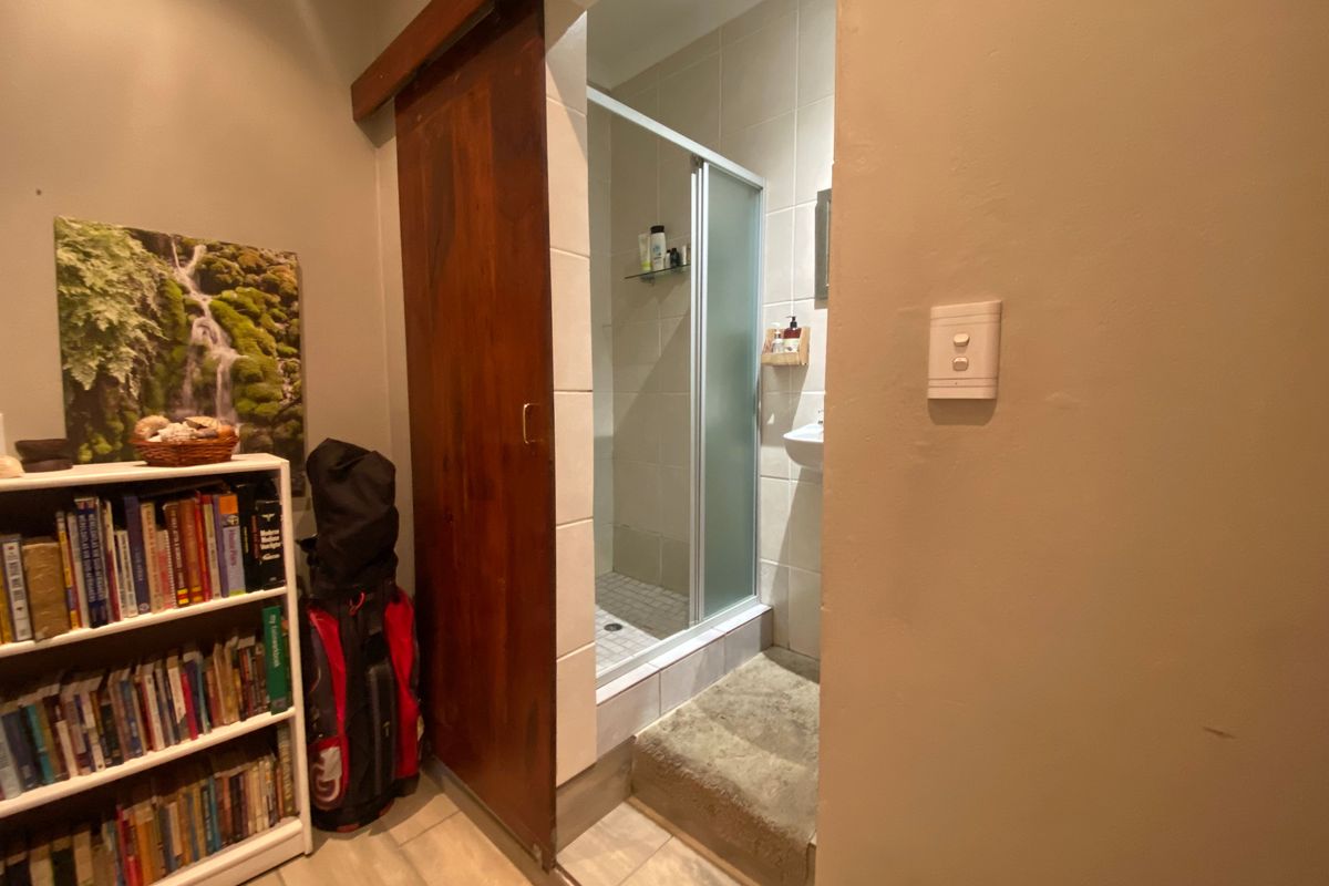 A bathroom featuring a sliding wooden barn door entry, tiled shower enclosure, and neutral wall finishes.