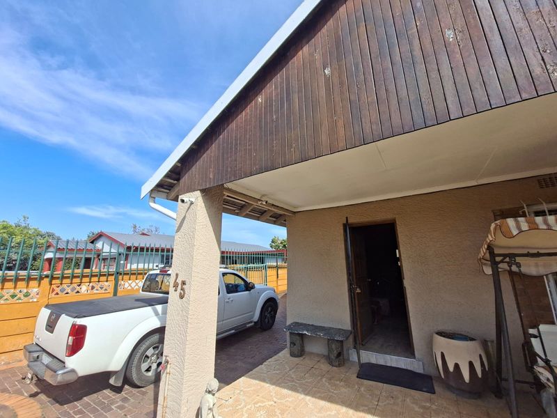 Front entrance area featuring a covered patio with tiled flooring and timber cladding on the upper facade.