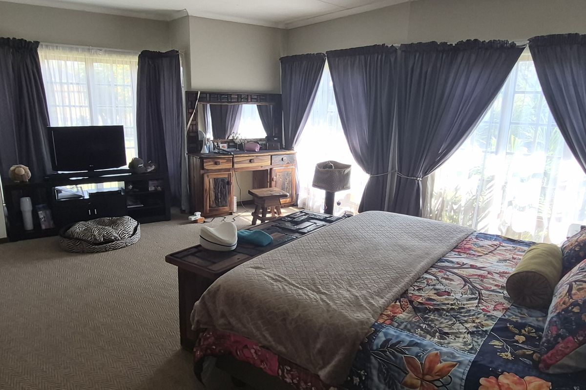 Spacious bedroom featuring neutral carpeting and large windows that allow for ample natural light.
