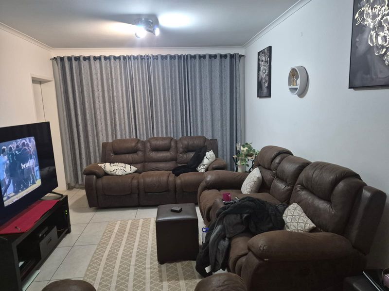 A comfortable living room featuring tiled flooring and neutral wall finishes, providing a functional space for relaxation and entertainment.