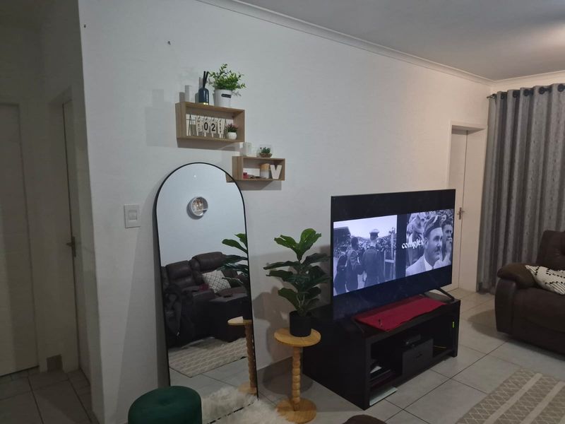 A living room area featuring tiled flooring and standard interior finishes, providing a functional space for relaxation.