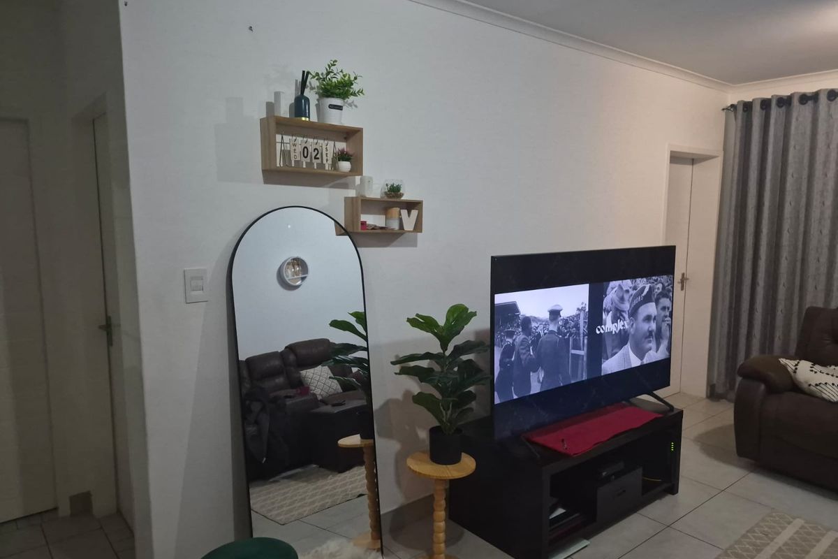 A living room area featuring tiled flooring and standard interior finishes, providing a functional space for relaxation.