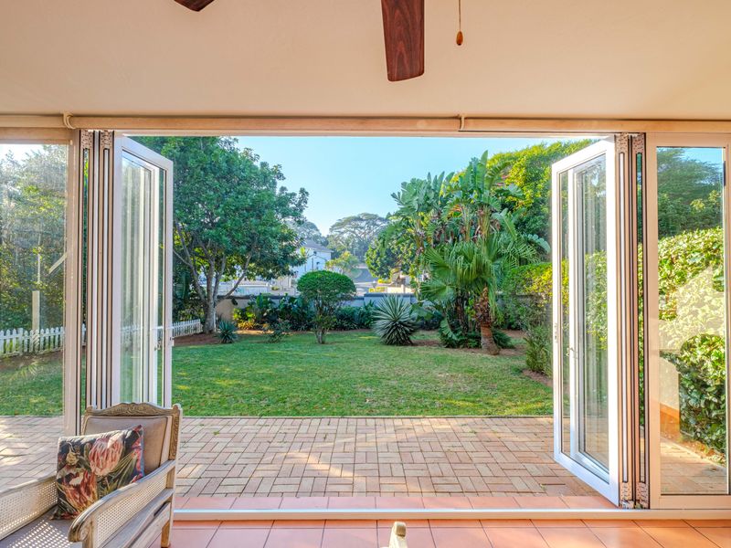 Covered patio featuring large bi-fold doors that open onto a private garden, providing seamless indoor-outdoor flow.
