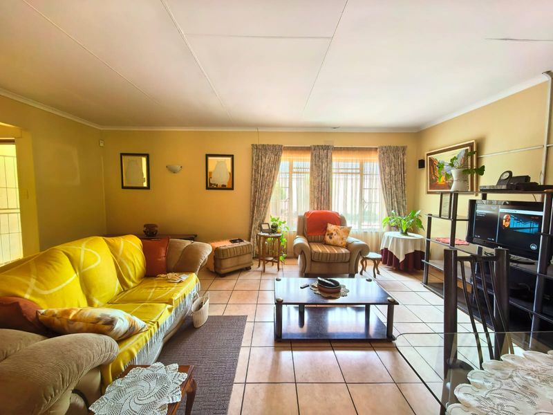 A spacious living room featuring neutral wall tones and tiled flooring, offering a comfortable and functional layout for relaxation.