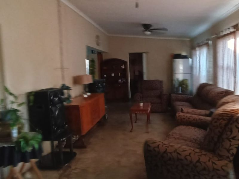 A living room area featuring a ceiling fan and access to an adjacent space through a sliding glass door.