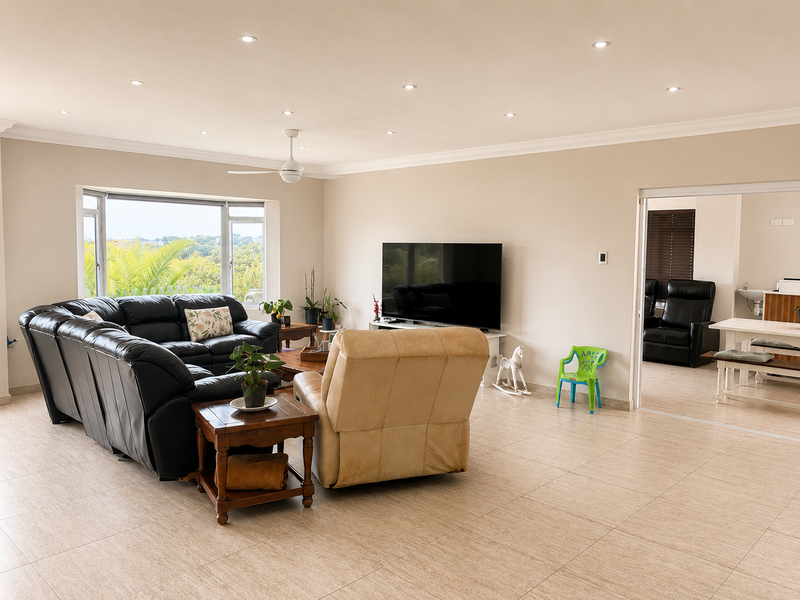 Spacious living room featuring neutral tiled flooring, recessed downlighting, a ceiling fan, and a large bay window with natural light.