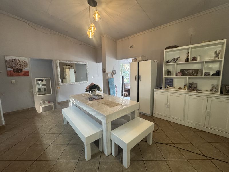 A dining area featuring tiled flooring, built-in cabinetry, and pendant lighting, offering a functional space for family meals.