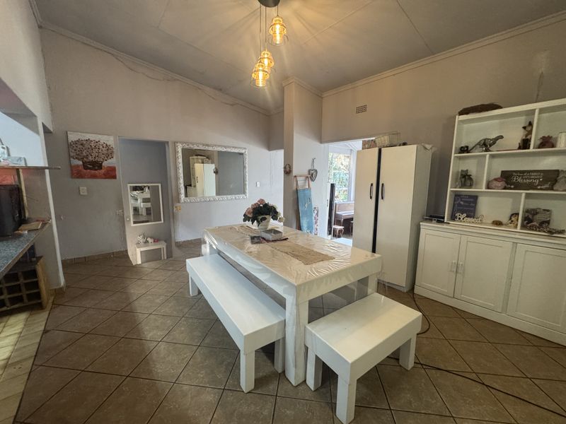 Spacious dining area featuring tiled flooring, pendant lighting, and built-in cabinetry, offering a functional space for family meals and gatherings.
