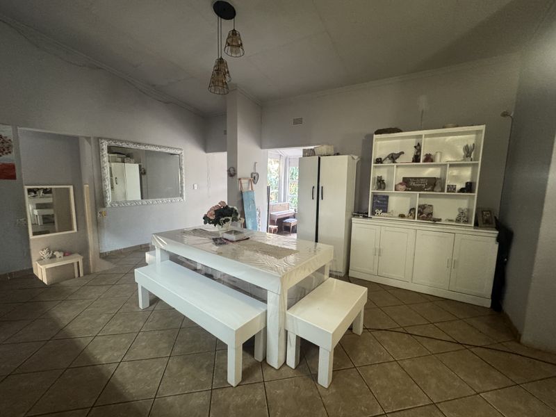 A dining area featuring tiled flooring, built-in storage cabinetry, and pendant lighting, offering a functional space for family meals.