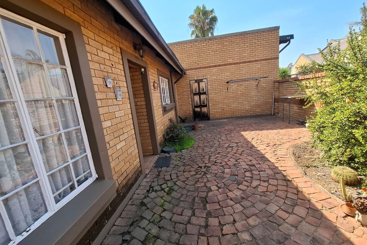 A rear courtyard area featuring face brick walls and circular pattern cobblestone paving, providing a functional outdoor space.