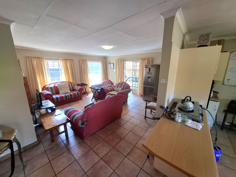 Open plan living and kitchen area featuring tiled flooring, neutral walls, and direct access to the exterior via sliding glass doors.