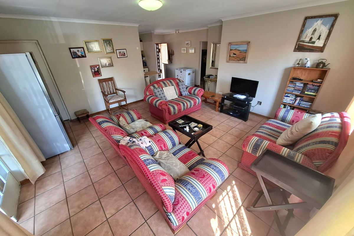 A spacious living room featuring neutral wall tones and durable tiled flooring, providing a functional and comfortable area for relaxation.