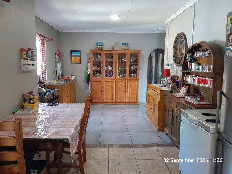 A functional kitchen area featuring tiled flooring, built-in wooden cabinetry, and integrated cooking appliances, offering a practical layout for daily meal preparation.