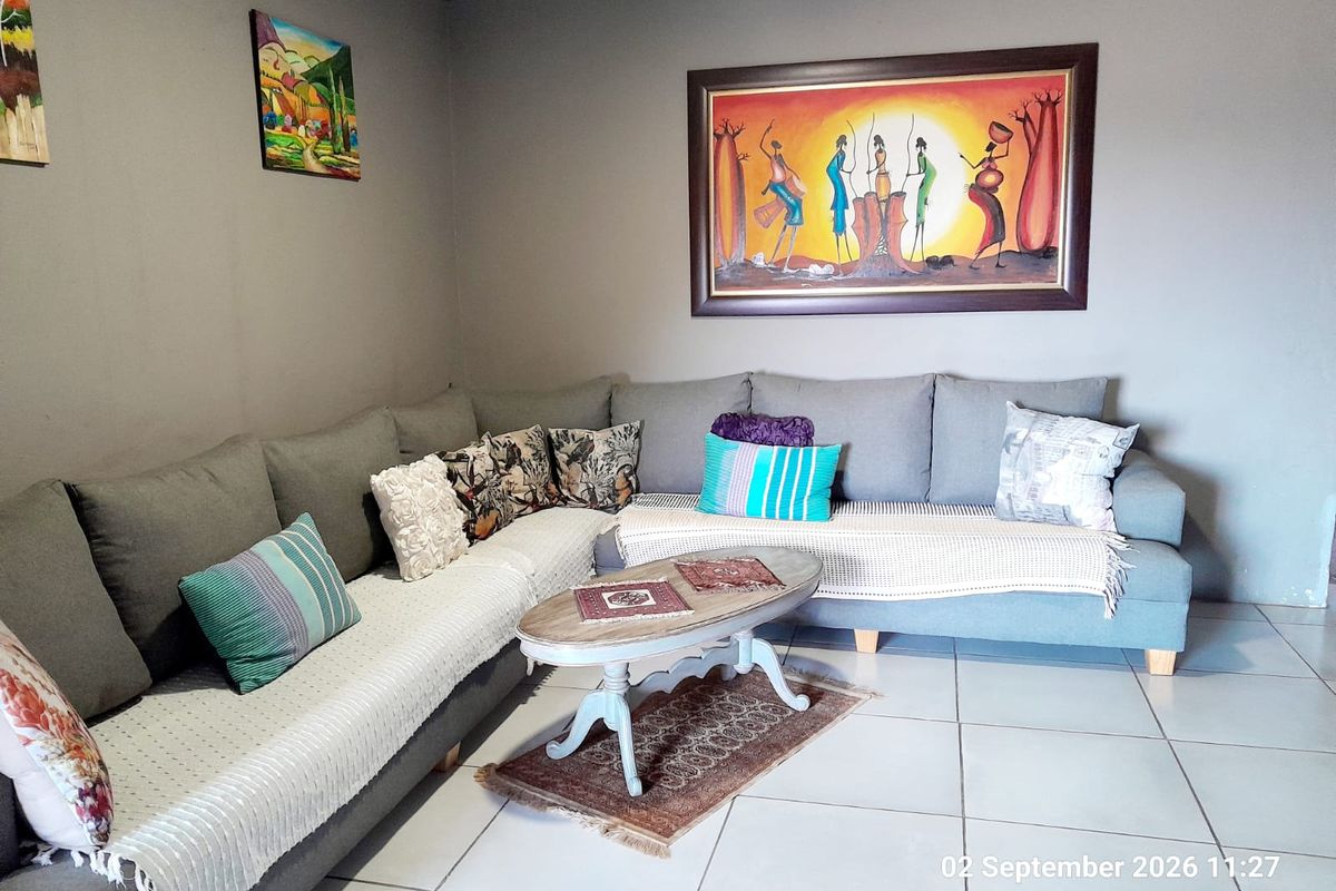 A comfortable living room featuring neutral wall tones and light-colored floor tiles, providing a clean and functional space.
