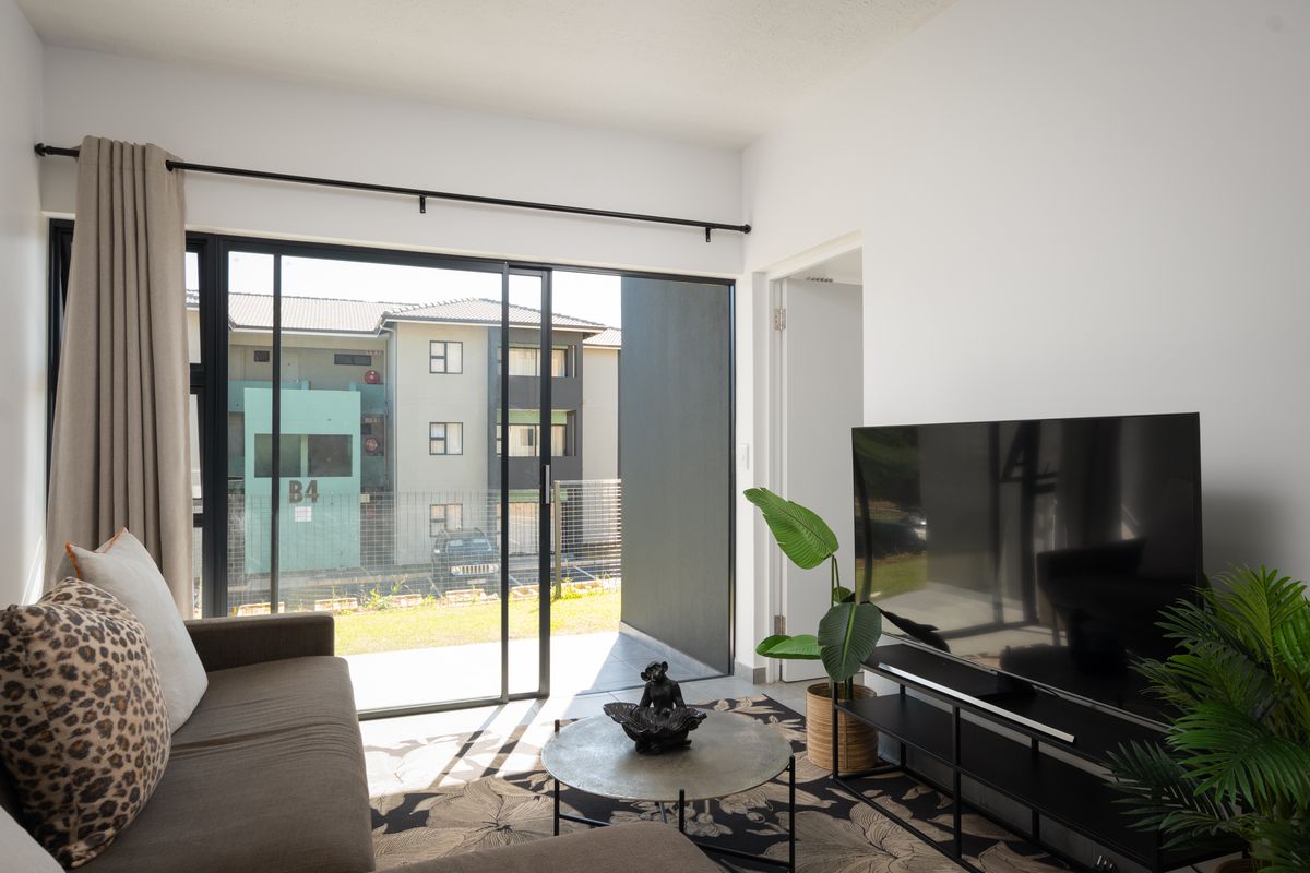 A bright living room featuring a large sliding glass door that provides access to an outdoor area and allows for ample natural light.