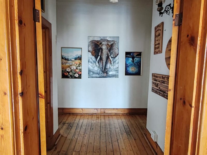 A hallway featuring natural timber flooring and traditional wooden door frames, providing a warm and classic transition between rooms.