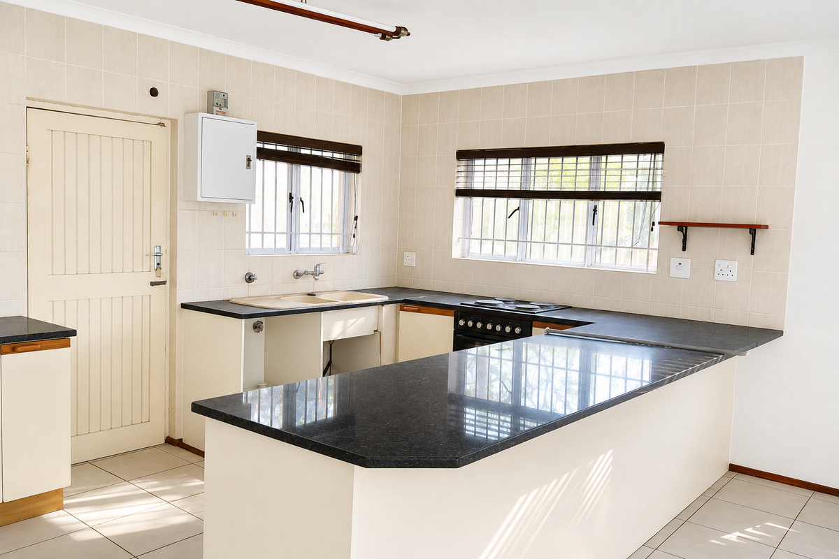 A functional kitchen featuring granite countertops, built-in stove, tiled splashback, and ample cabinetry, currently vacant and ready for a modern update.