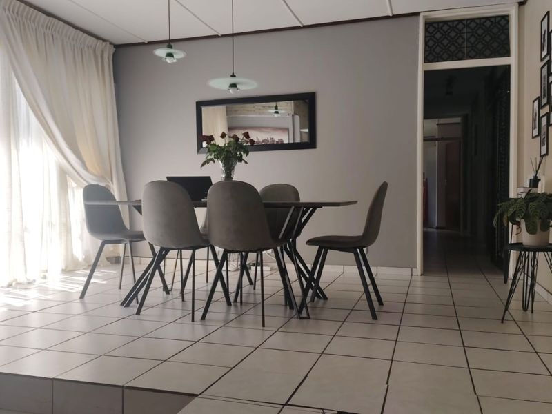 Dining area featuring a raised tiled platform, pendant lighting, and access to a patio through sliding glass doors.
