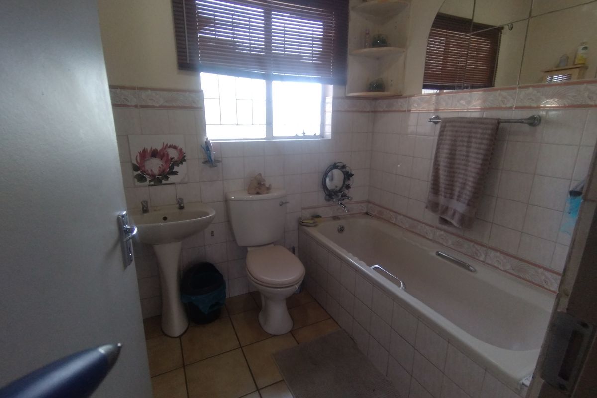 A dated bathroom featuring a pedestal basin, toilet, and bathtub with tiled walls and flooring, requiring modernization to improve aesthetic appeal.