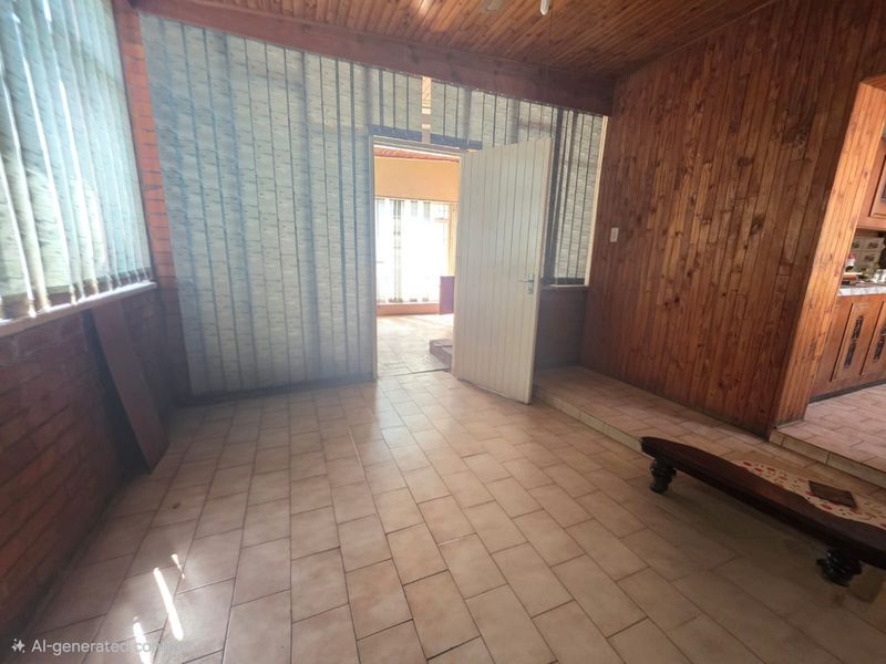 An interior living space featuring timber-paneled walls, a timber ceiling, and tiled flooring, offering a dated aesthetic ready for modernization.