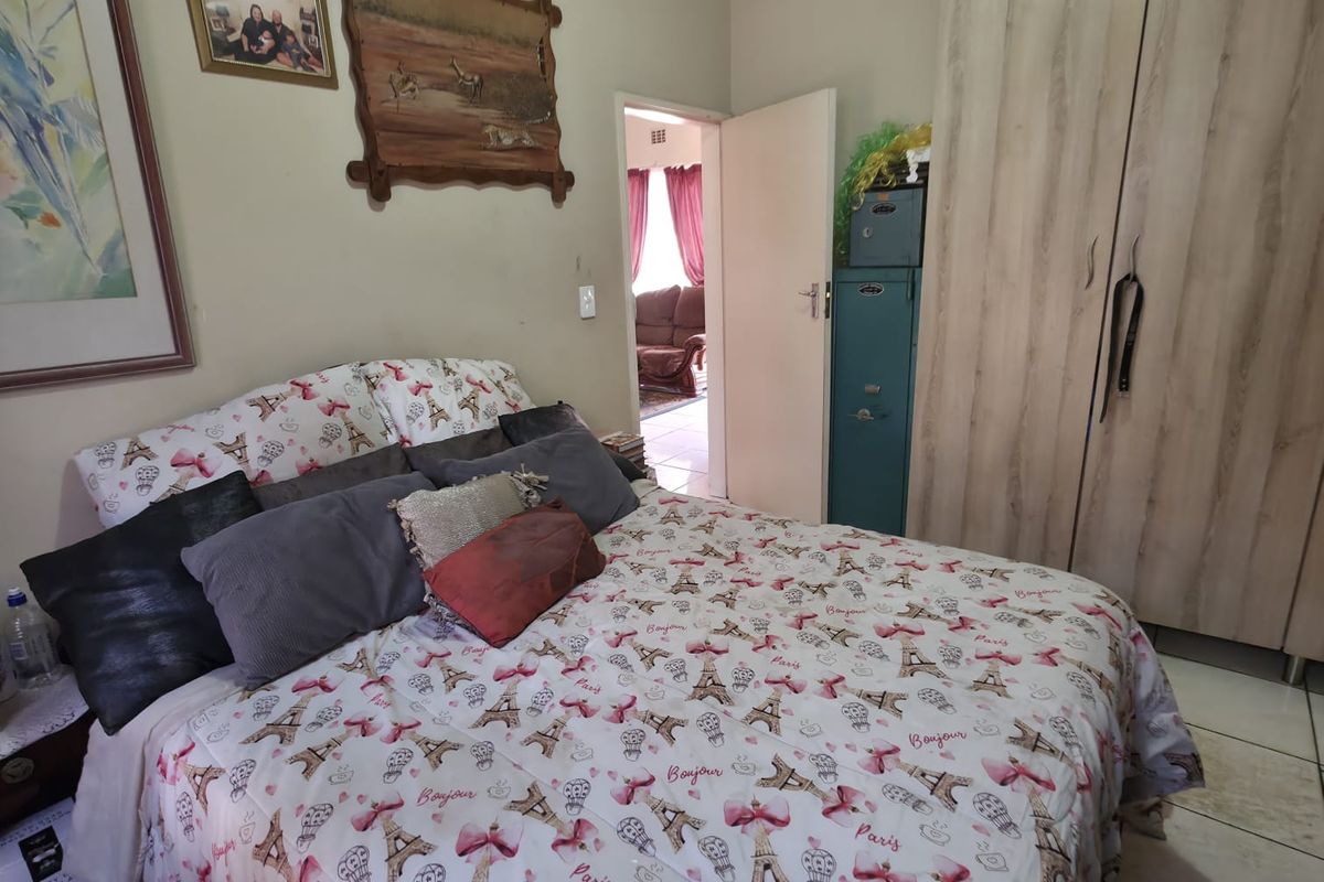A bedroom featuring tiled flooring and a built-in wardrobe, offering a functional space with direct access to an adjacent room.