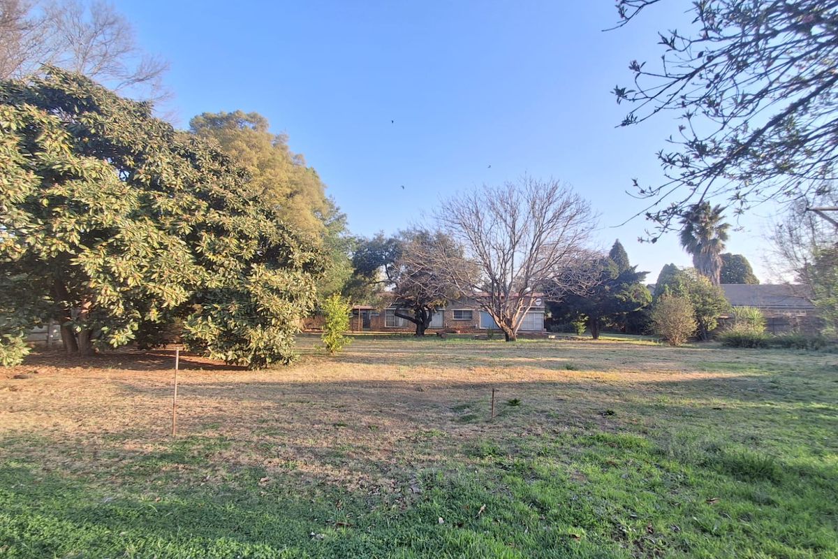 A spacious rear garden featuring mature trees and established landscaping, providing a private outdoor setting for the property.