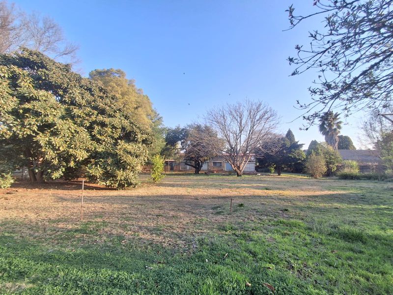 A spacious rear garden featuring mature trees and established landscaping, providing a private outdoor setting for the property.