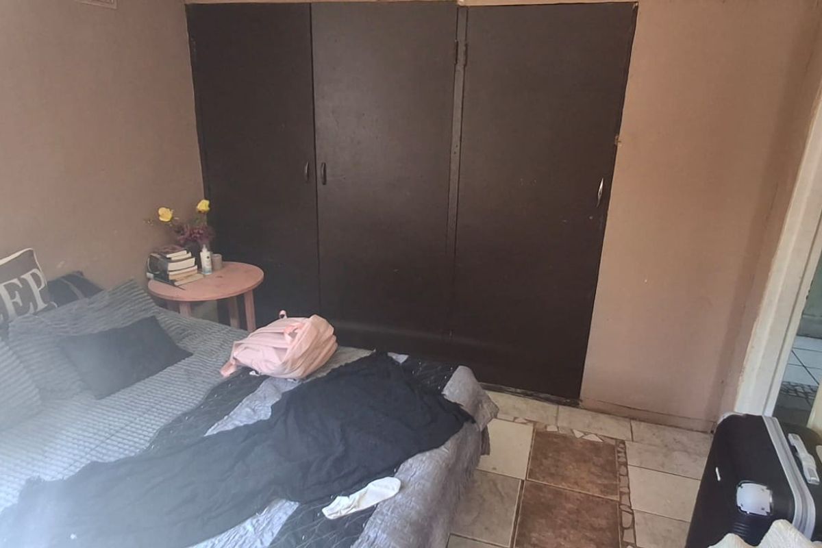 A bedroom featuring built-in cupboards and tiled flooring, requiring cosmetic updates to improve the overall aesthetic and condition of the space.