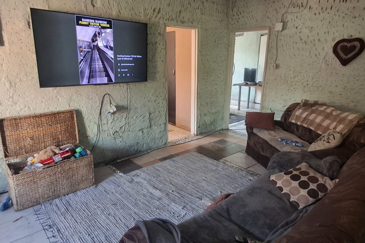 A living room area featuring textured plaster walls and tiled flooring, providing a rustic foundation for potential interior updates and modernization.