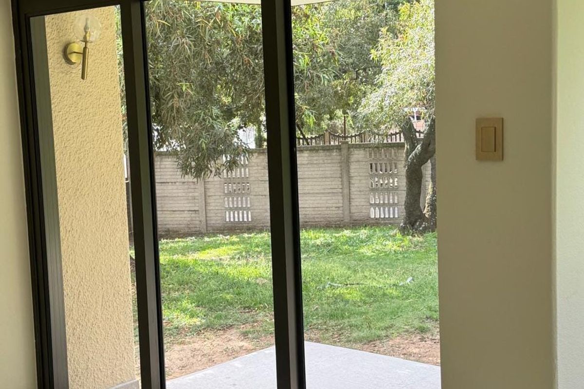 Bright living area featuring large sliding glass doors that open onto a private patio and garden space.