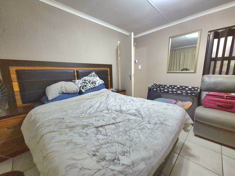 A functional bedroom featuring tiled flooring and neutral wall finishes, providing a comfortable and practical living space.