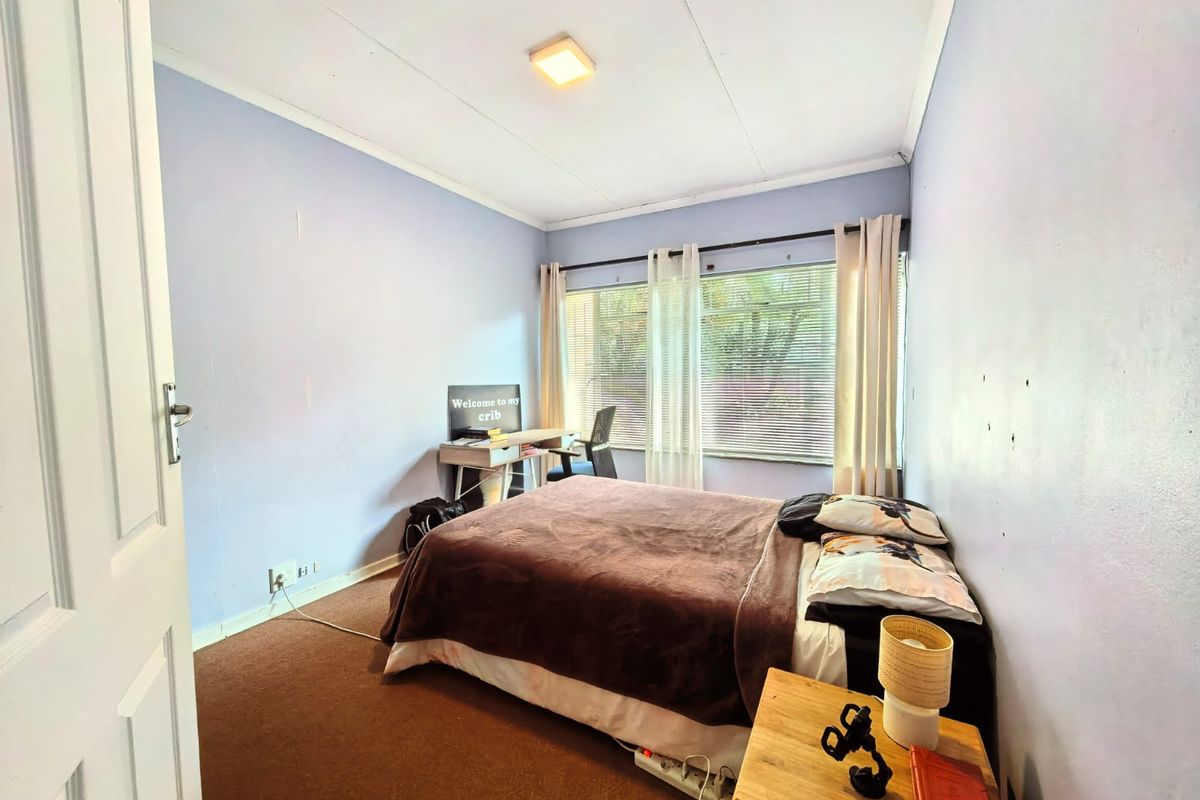 A bedroom featuring carpeted flooring, window blinds, and curtain rails, requiring cosmetic updates to the wall surfaces and flooring to enhance its appeal.